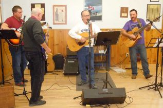 L-r, Adam Lake, Jim MacPherson, Cliff Rines and Justin Riddell on stage for the Open Mic Rink Fundraiser event at the Sharbot Lake Legion